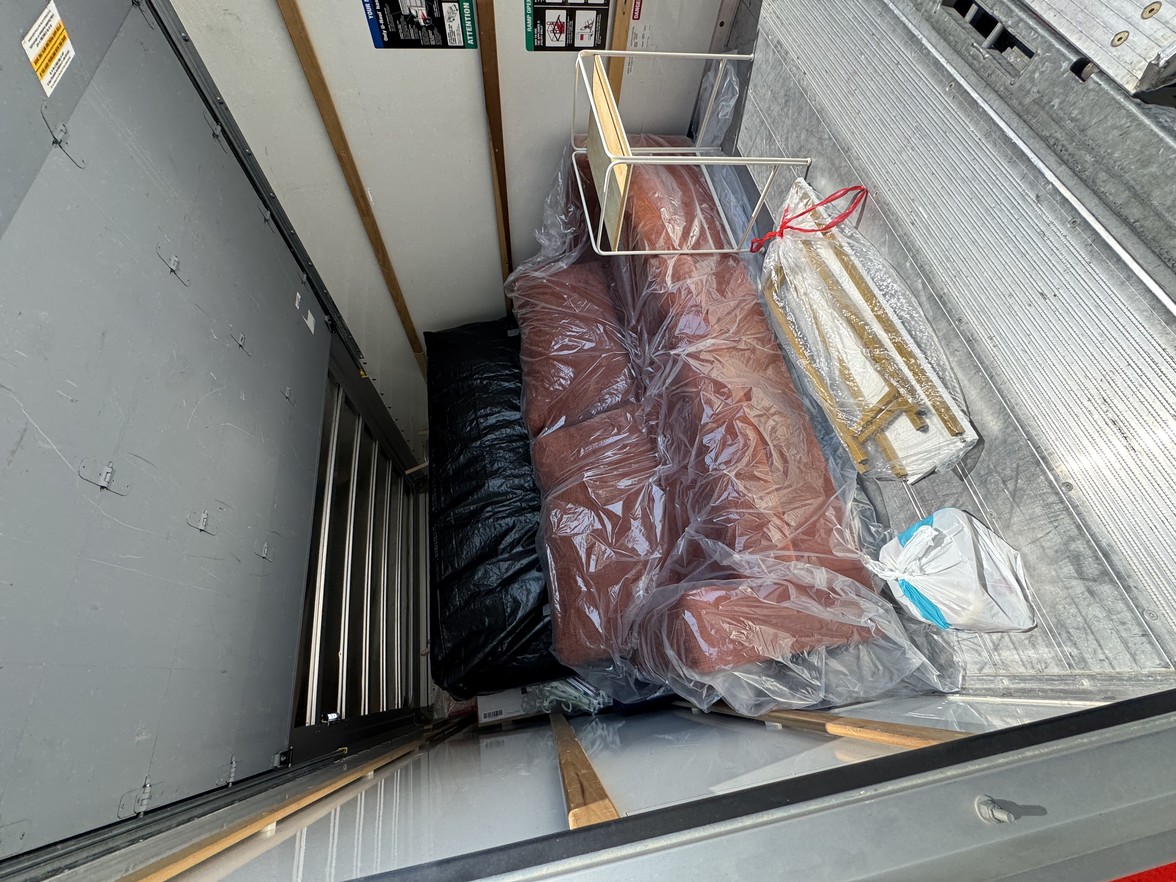 Commercial moving team carefully rolling wrapped office desks, chairs, and equipment during a business relocation in Nashville